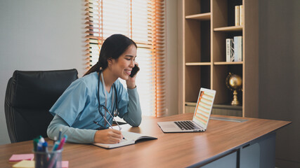 doctor female in office using laptop and smartphone 