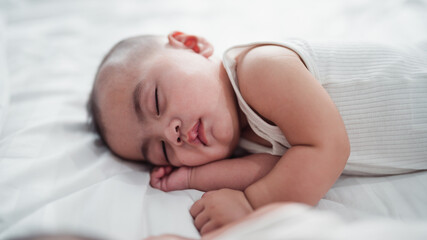 The baby is lovely, sleeping happily and relaxing in bed.