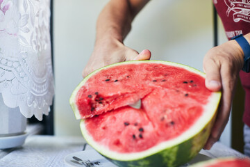 Juicy red watermelon is cut with a knife. The concept of summer and delicious vegetables. Front view.