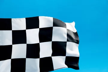  Checkered flag waving on blue background © xy