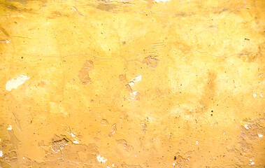 Dirty gold yellow concrete wall with cracked and peeling texture on  background