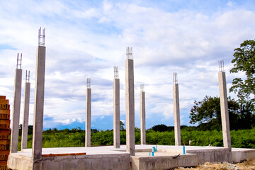 Construction site background  ,reinforced concrete pole of the new house building on blue sky cloud...