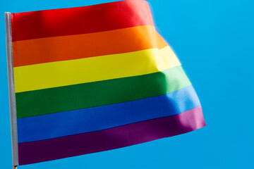 Fototapeta na wymiar Rainbow flag waving on blue background