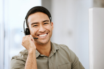 Smiling, friendly call center agent with headset for online consulting in an IT tech agency. Face of male ecommerce support professional offering virtual assistance to web user or contact us hotline - obrazy, fototapety, plakaty