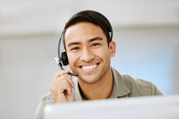 Smiling, friendly call center agent with headset for online consulting in an IT tech agency. Face of male ecommerce support professional offering virtual assistance to web user or contact us hotline