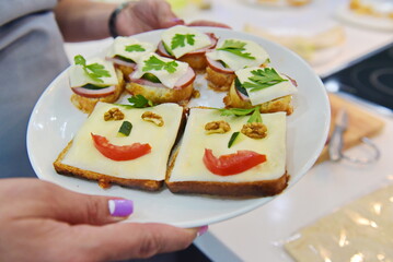 Almaty, Kazakhstan - 08.28.2015 : Toast with cheese and herbs on a plate. Cooking breakfast.
