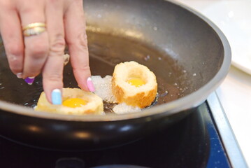 Almaty, Kazakhstan - 08.28.2015 : Breaking quail eggs into bread toasts for toasting.
