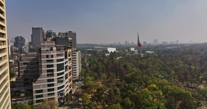 Mexico City Aerial v94 low level flyover campo marte with huge mexican flag waving on the field next to national auditorium at bosque de chapultepec park - Shot with Mavic 3 Cine - January 2022