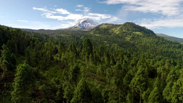 backwards drone shot showing the snowy top of the popocatepetl volcano in mexico city