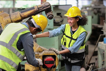 Group of professional heavy industry technician engineer in safety workwear repair part of broken robot arm machine in intelligent factory automotive. Industrial and technology support system concept