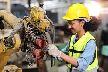 Fototapeta premium Professional heavy industry technician engineer in safety workwear repairing part of broken robot arm machine in intelligent factory automotive. Industrial and technology support system concept