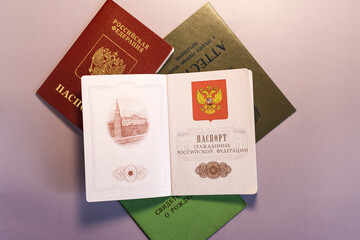 The spread of the first pages of the passport of the Russian Federation against the background of other civil documents