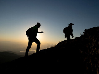 team of mountaineers hiking at sunrise time