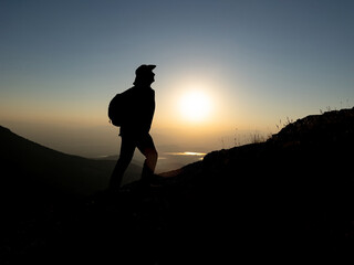 mountaineer hiking at sunrise on summit