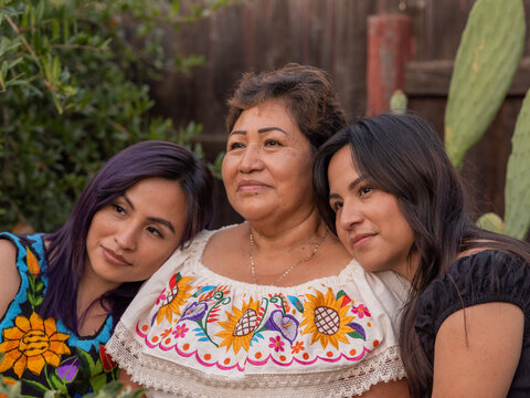 Young Indigenous women leaning their heads on an older Indigenous woman 