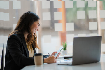 Asian business woman working in finance with laptop and smartphone, accounting concept.