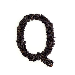 Capital letter Q made from sunflower seeds. Alphabet made from sunflower seeds. White background. Sunflower seed font