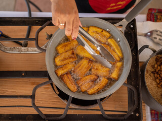 Overhead image of plantains frying in a pan on a stovetop  © INDÍGENA