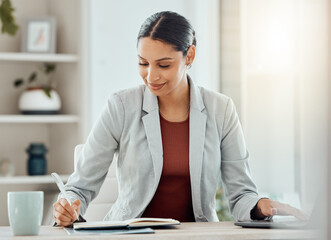 Female manager, boss or CEO writing notes in her diary, marking appointments in her calendar or...