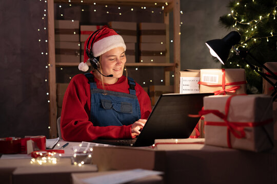 small business owner freelance santa working at home office using computer at night, packaging box for online marketing christmas gifts, e-commerce for SME, christmas sale