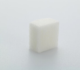 One sugar cube on white background