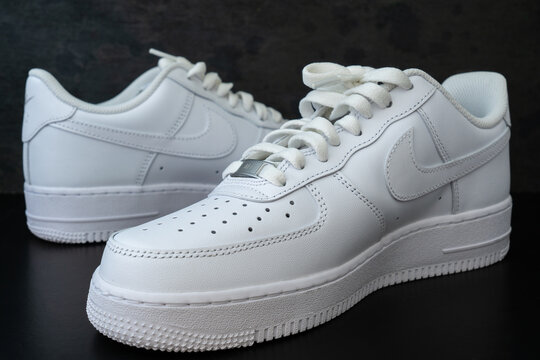 DOHA, QATAR - AUGUST 17, 2022: Nike Air Force 1 white sneakers isolated on dark background. Illustrative editorial photo.