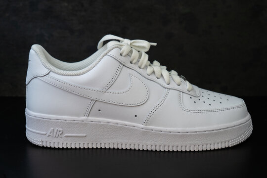 DOHA, QATAR - AUGUST 17, 2022: Nike Air Force 1 white sneakers isolated on dark background. Illustrative editorial photo.
