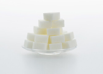 Sugar cubes on a plate on white background