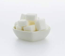 Sugar cubes in a heart shaped bowl on white background
