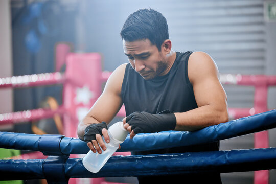 Sad, lose and defeated athlete looking tired after workout, unhappy and drinking water after boxing for fitness. Young, sporty and Asian man breathing heavily, resting and taking break from exercise