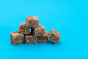 pile of brown sugar cube on blue background