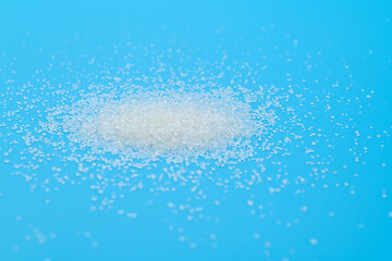 White sugar crystals on blue background