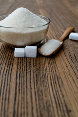 A bowl granulated sugar and sugar cubes on the table