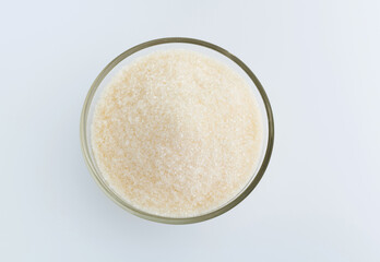Granulated sugar in a bowl on white background