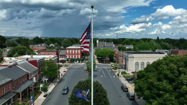 Flags of PA Pennsylvania and USA in town square. Aerial on summer day.