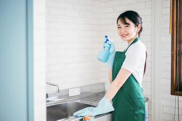 水回りの掃除をするハウスキーパーの女性
