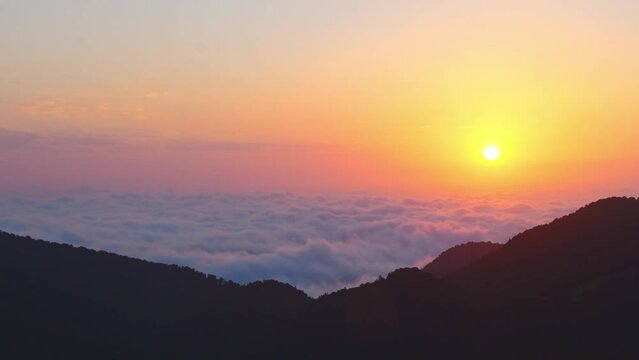 Static aerial panoramic view of sun rising above horizon with clouds above forest. Weather and forecast background