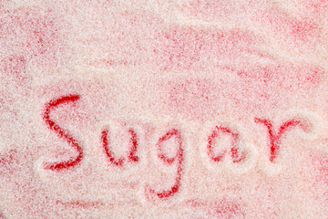 Fototapeta premium The word sugar written on granulated sugar