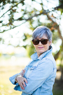 portrait of a senior woman in the garden wearing sunglasses