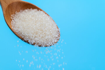 Sugar crystals falling out of wooden spoon