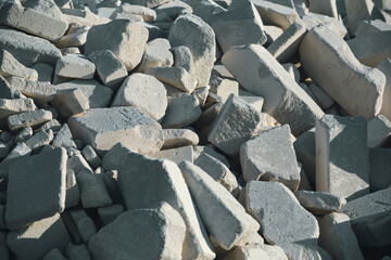 A broken white brick is randomly lying in a pile. Construction debris, unauthorized landfill. environmental pollution. A pile of stones in close-up.