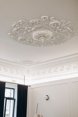white ceiling details with classic stucco. patterns on the ceiling of the room.