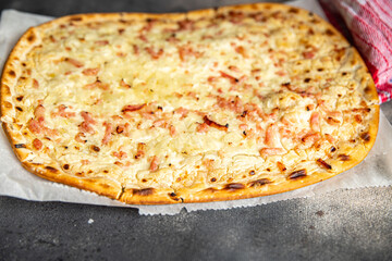 Flammkuchen savory pie bacon, onion, sour cream pastrie meal food snack on the table copy space food background - obrazy, fototapety, plakaty