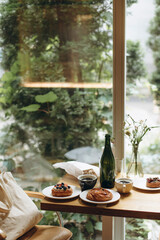 a table with coffee and sweet buns near the window in a cafe. two cups of black coffee with sweet desserts on a table in a coffee shop.