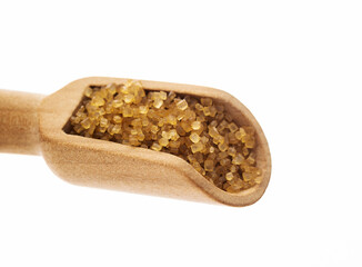 Wooden scoop of brown sugar on white background