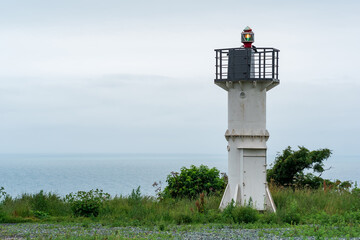 automatic lighthouse with sector light on a high cape above the sea harbor