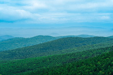 Fototapeta premium aerial view of wild wooded hills on a cloudy day