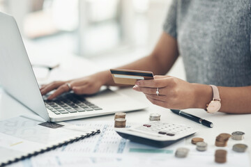 Budget with technology for online shopping and working indoors. Closeup of financial advisor counting money on laptop in the office. Businesswoman holding card, coins and calculator on table.