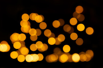 Yellow defocused lights, bokeh on black background, overlay. Design element. Christmas, New Year