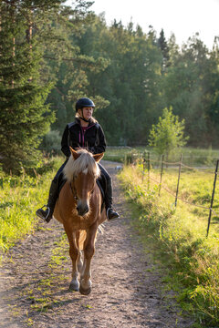 Woman horseback riding in forest parth